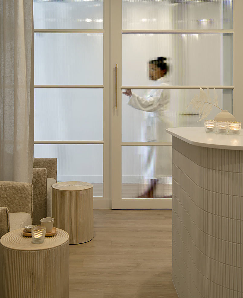 A woman walks behind a glass door in BODHI cottesloe spa